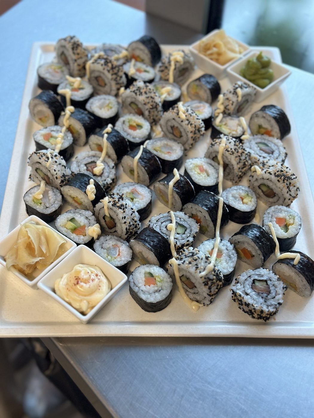 Platte mit Sushi-Rollen, Ingwer und Dips