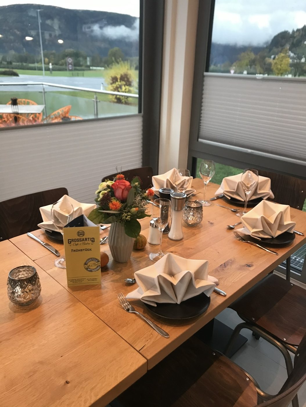 Festlich gedeckte Tafel mit gefalteten Servietten, Blumen und Kerzen im Grossartig