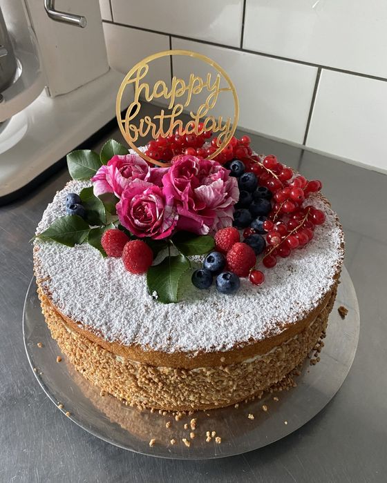 Geburtstagstorte mit Rosen, Beeren und Staubzucker